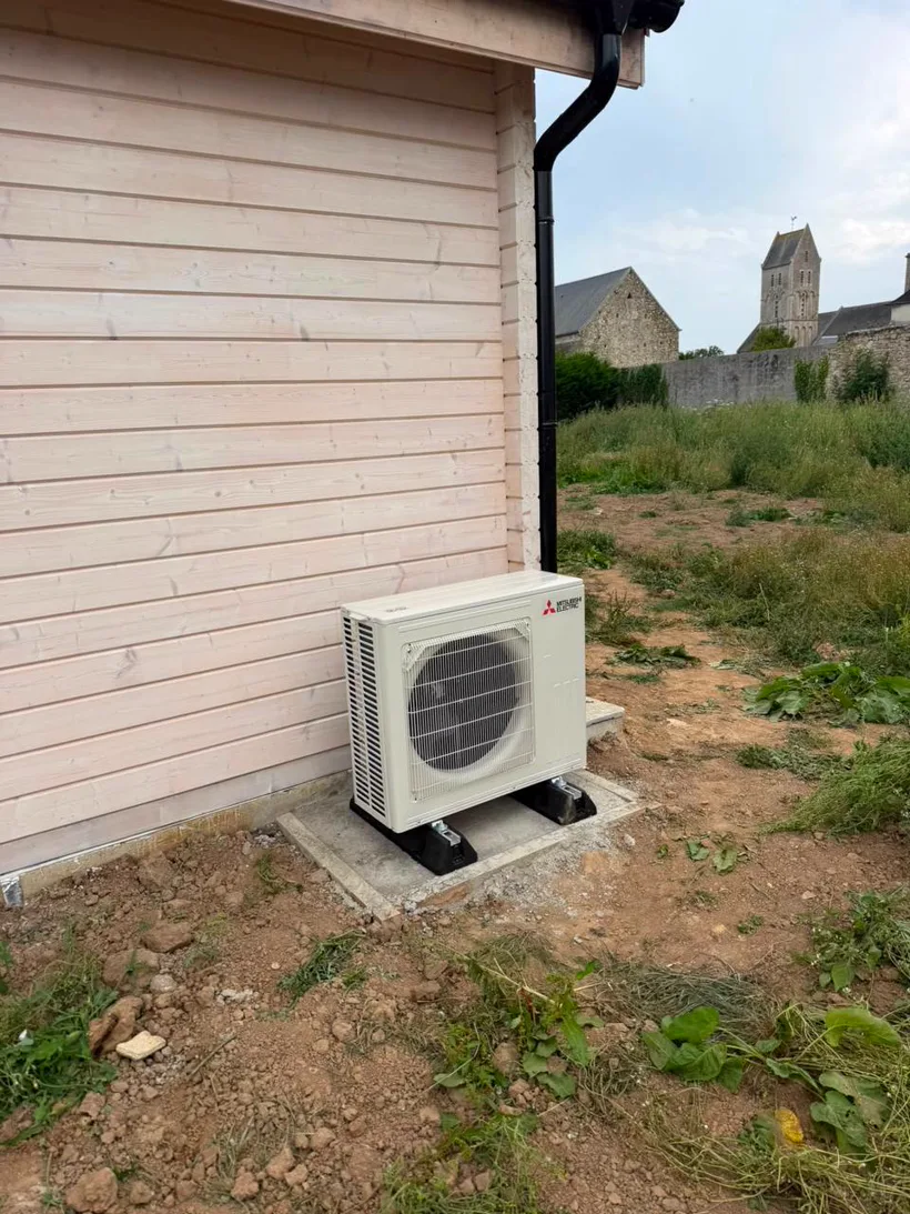 Pompe à chaleur Mitsubishi Electric installée à Longueville, clocher du village en arrière-plan